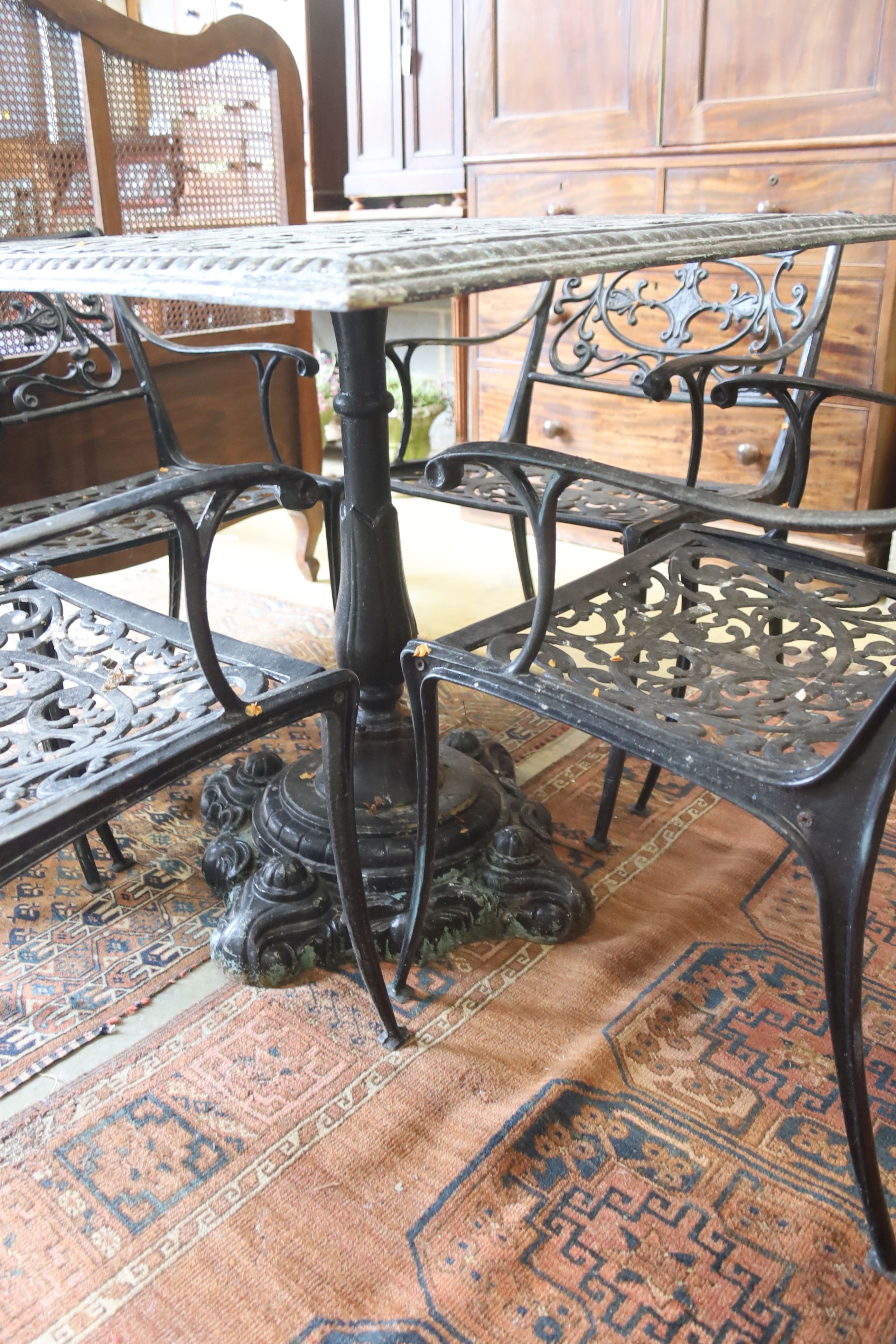 A Victorian style square cast metal garden table, width 88cm, height 72cm and four elbow chairs (one a.f.)